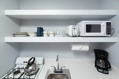 a kitchen with a sink and a microwave on a shelf at Shell on the Beach 103 - RENOVATED in Hollywood