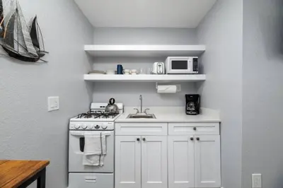 a white kitchen with a stove and a microwave at Shell on the Beach 103 - RENOVATED in Hollywood