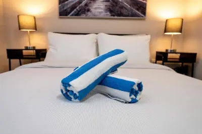 a bed with a blue and white towel on it at Shell on the Beach 101 in Hollywood