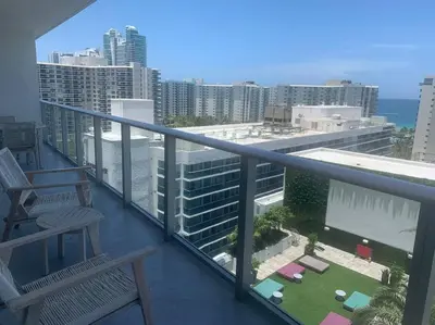 a balcony with two chairs and a view of the ocean at Luxury apartment- Hyde House Resort in Hollywood