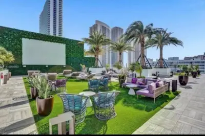 a patio with chairs and tables and palm trees at Luxury apartment- Hyde House Resort in Hollywood
