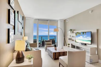 a living room with a couch and a tv at Ocean View Balcony, Beachfront Resort, Amazing Pool in Hollywood