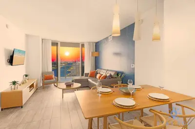 a living room with a table and a couch at Infinite View, Balcony, Gym, Amazing Pool in Hallandale Beach