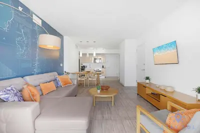a living room with a couch and a table at Infinite View, Balcony, Gym, Amazing Pool in Hallandale Beach