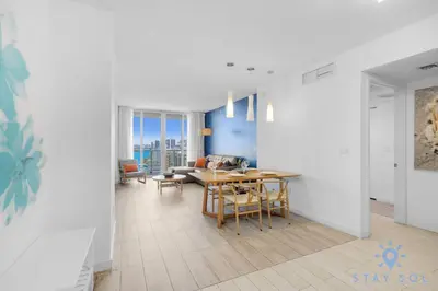 a dining room and living room with a table and chairs at Infinite View, Balcony, Gym, Amazing Pool in Hallandale Beach