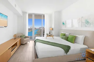 a bedroom with a large bed and a large window at Infinite View, Balcony, Gym, Amazing Pool in Hallandale Beach