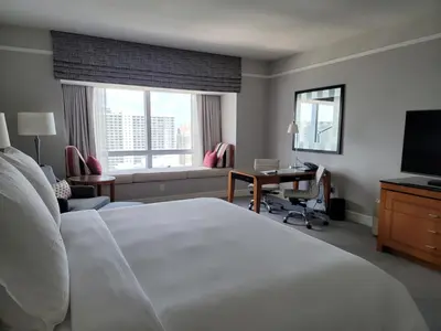 a hotel room with a bed and a desk and a television at Four Seasons Studio - Privately Owned Unit in Miami