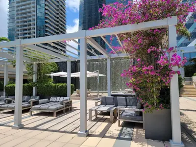 a pergola with benches and flowers on a patio at Four Seasons Studio - Privately Owned Unit in Miami