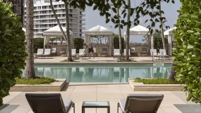 a swimming pool with chairs and a building at Four Seasons Studio - Privately Owned Unit in Miami