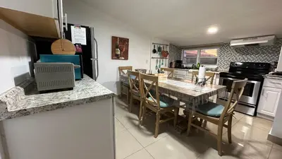 a kitchen and dining room with a table and chairs at Private Rooms in Miami