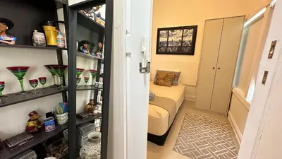 a small living room with a couch and shelves at Private Rooms in Miami