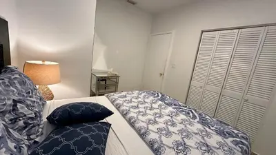 a living room with a couch with blue and white pillows at Private Rooms in Miami