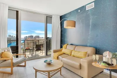 a living room with a couch and a table at Infinite View with Balcony, Gym, Pool in Hallandale Beach