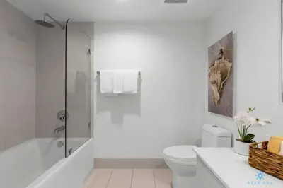 a white bathroom with a shower and a toilet at Infinite View with Balcony, Gym, Pool in Hallandale Beach