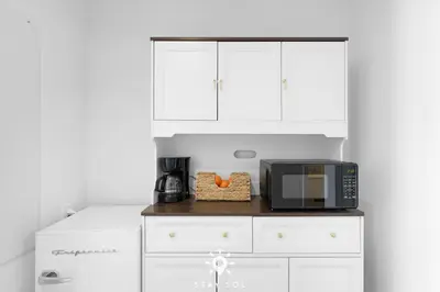 a kitchen with white cabinets and a black microwave at Infinite View - Balcony - Pool - Gym - Near Beach in Hallandale Beach