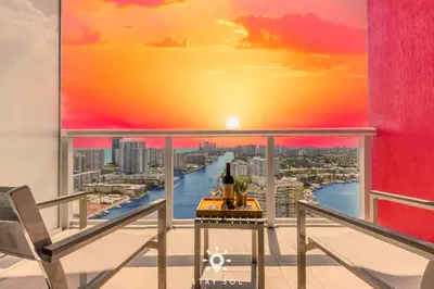 a balcony with a view of a river and a sunset at Infinite View - Balcony - Pool - Gym - Near Beach in Hallandale Beach