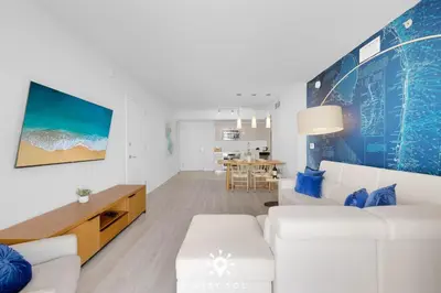 a living room with a white couch and a table at Infinite View - Balcony - Pool - Gym - Near Beach in Hallandale Beach