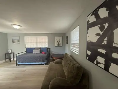 a living room with a bed and a couch at Modern cozy home with private patio - Sleeps 6 in Miami