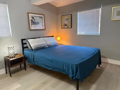 a bedroom with a bed with a blue comforter at Modern cozy home with private patio - Sleeps 6 in Miami