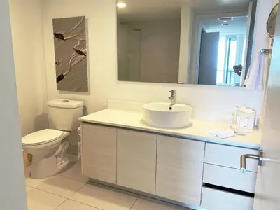 a bathroom with a sink and a toilet and a mirror at Stylish Miami Beach Getaway, Ocean Views & Gourmet Kitchen -12A in Hallandale Beach