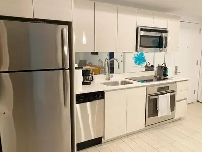 a kitchen with a stainless steel refrigerator and a sink at Boutique-Style Miami Apt, Comfort, Design & Sea View -26A in Hallandale Beach