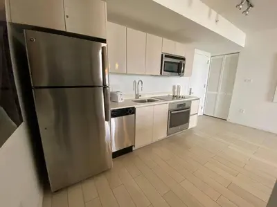 a large kitchen with a stainless steel refrigerator at Boutique-Style Miami Apt, Comfort, Design & Sea View -26A in Hallandale Beach