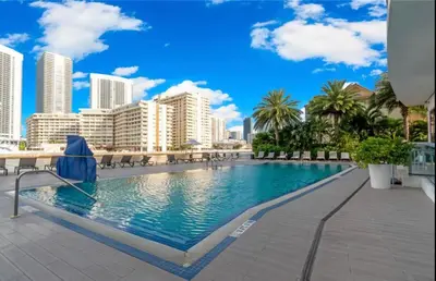 a swimming pool with a city skyline in the background at Upscale Beach Apartment, Style, Views & Complete Kitchen -28A in Hallandale Beach