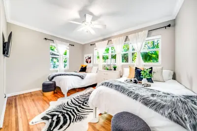 a zebra themed bedroom with two beds and a couch at Tropical Jungle Pool Oasis in Fort Lauderdale