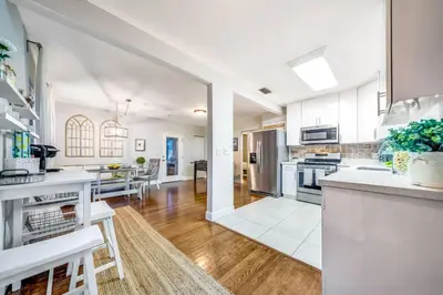 a kitchen with white cabinets and a large open floor plan at Pool and Beach Relaxing Close to Everything in Dania Beach