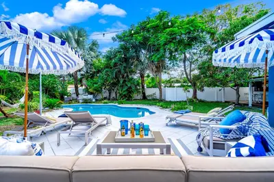a patio with a couch and chairs and a pool at Pool and Beach Relaxing Close to Everything in Dania Beach
