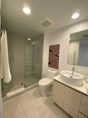a bathroom with a toilet and a sink and a shower at Sunlit BeachWalk Studio 2 Full Beds Coastal Charm -26B in Hallandale Beach
