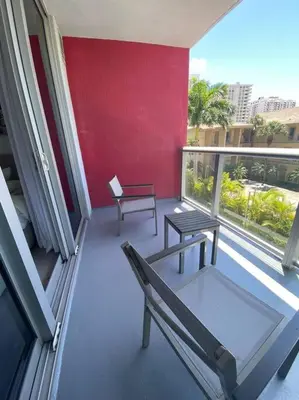 a balcony with two chairs and a bench on a building at Sunlit BeachWalk Studio 2 Full Beds Coastal Charm -26B in Hallandale Beach