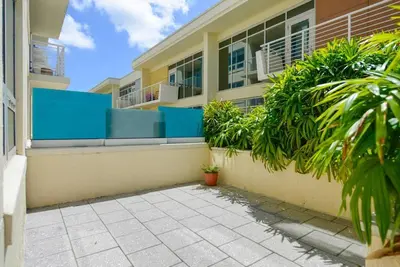a building with blue and yellow walls and plants at Awesome Apt With Pool in Midtown Miami in Miami