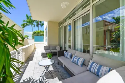 a patio with a couch and a table on a balcony at Awesome Apt With Pool in Midtown Miami in Miami