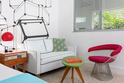 a living room with a chair and a couch at The Vagabond Hotel Miami in Miami