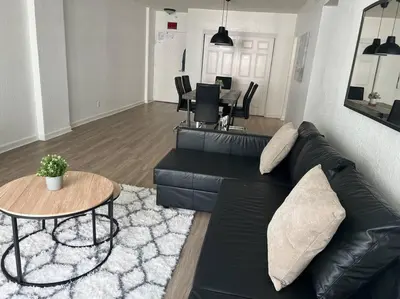 a living room with a black leather couch and a table at The Tides! On the beach, Sea view! in Hollywood