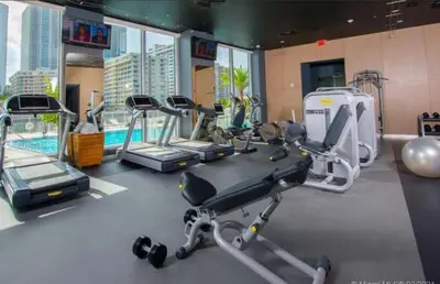 a gym with cardio equipment and a swimming pool at Stunning Penthouse Suite Waterfront 2BD 2BA in Hallandale Beach