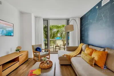 a living room with a couch and a table at Apartment with Balcony, Gym & Near Beach in Hallandale Beach
