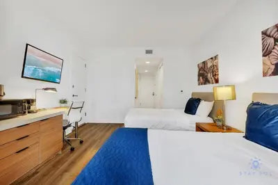 a hotel room with two beds and a tv at Modern Resort - Apartment with Balcony, Pool and Gym in Hallandale Beach