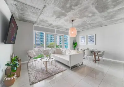a living room with a white couch and a table at Amazing Condo with Pool at Midblock Miami in Miami