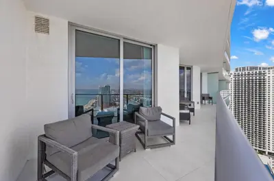 a balcony with chairs and a table on a building at Lyfe Oceanview Resort Luxury 2 Bedroom Unit in Hollywood