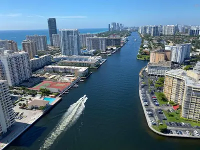a boat traveling down a river in a city at Chic Beach Studio Walk to Shore Sleeps 4 -14B in Hallandale Beach