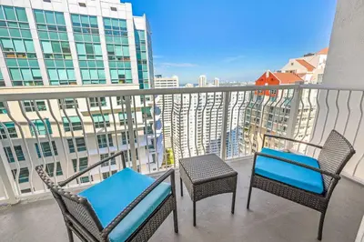 two chairs and a table on a balcony with buildings at High Floor Unit Located in Brickell - Free Parking in Miami
