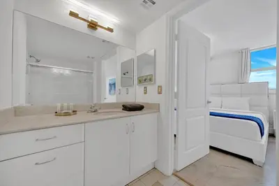 a white bathroom with a sink and a bed at 40th Floor Priceless Unit Central Location in Miami