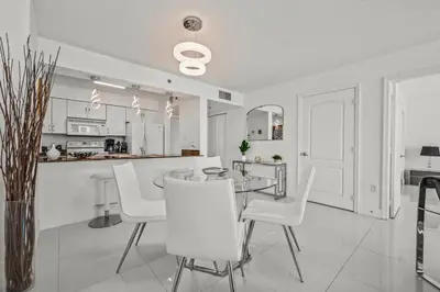 a white kitchen and dining room with a table and chairs at High Floor Ocean view Unit In Brickell in Miami