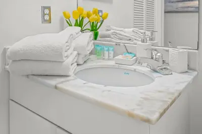 a bathroom counter with a sink with towels on it at INCREDIBLE OCEAN VIEW 3 BEDROOMS UNIT in Miami