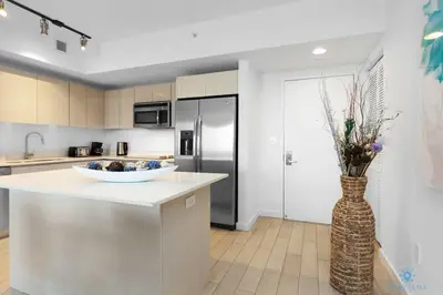 a kitchen with a counter and a vase with flowers at Infinite View - Balcony- Amazing Pool- Near Beach in Hallandale Beach