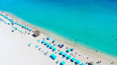 an overhead view of a beach with blue umbrellas and people at Ocean View Private Residence at South Beach - 804 in Miami Beach