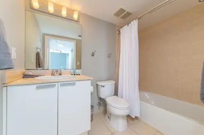 a bathroom with a toilet and a sink and a tub at 16699 Collins Ave Unit 2906 in La Perla in Miami Beach