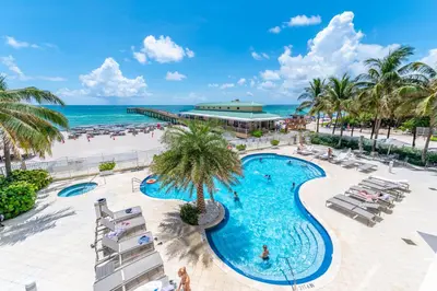 an aerial view of a resort swimming pool and the beach at 16699 Collins Ave Unit 2906 in La Perla in Miami Beach